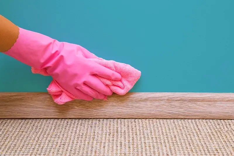 cleaning a wall pink gloves and cloth