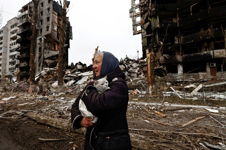 A woman carries her cat past buildings destroyed by Russian shelling in Borodyanka, Kyiv region, April 5, 2022.