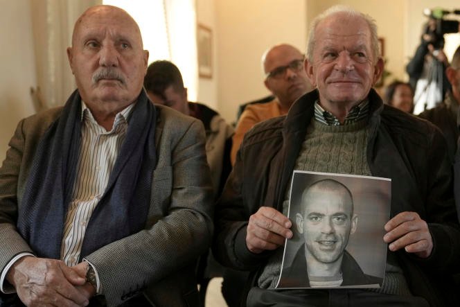 Hasan Hamouri (à droite) holds a picture of his son, Salah, during a press conference in Jerusalem on December 2, 2022.