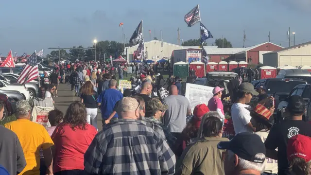 Crowds bustle together with Trump-Vance flags flying above