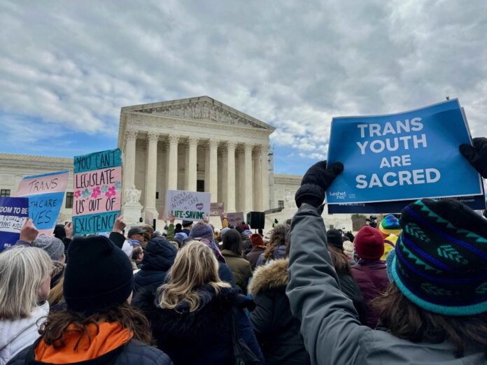 A crowd holding signs outside the Supreme Court